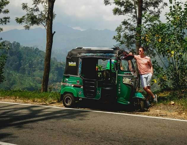 Tourist standing beside a tuk tuk in Colombo, ready to explore the city