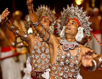 Traditional Kandyan dancers in colorful costumes performing at cultural show in Kandy