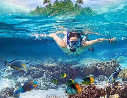 Woman snorkeling with tropical fish at Pigeon Island, Trincomalee, Sri Lanka