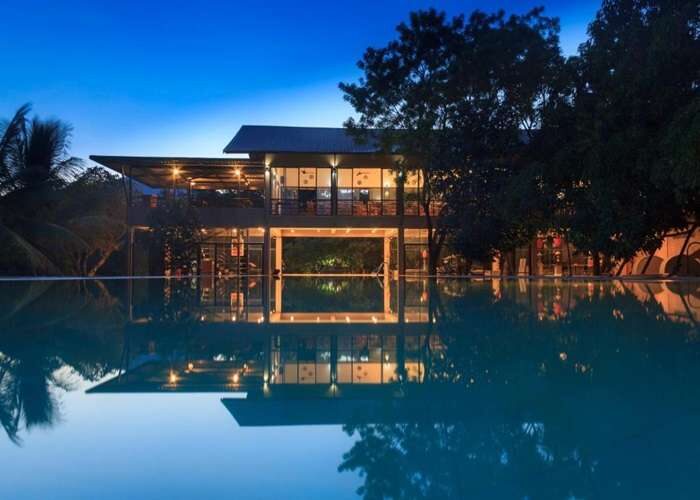 Night view of Sigiriyana Hotel pool with lights in Sri Lanka