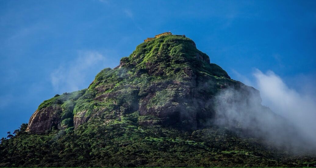 Adam’s Peak Sri Lanka surrounded by fog and greenery with blue sky in Nallathanniya