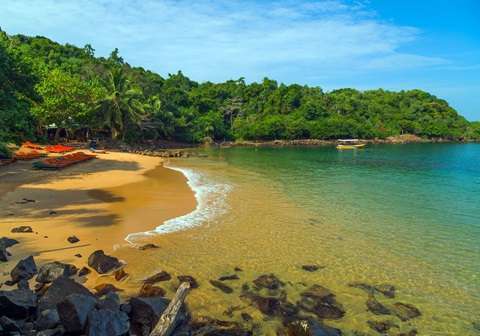 Jungle Beach with clear water and lush green surroundings