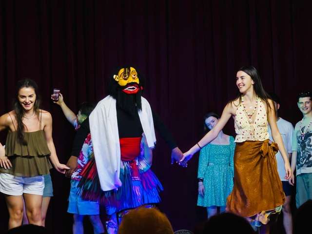 Guest dancing with a traditional Yaka performer during the Kandy Cultural Dance Show in Sri Lanka.