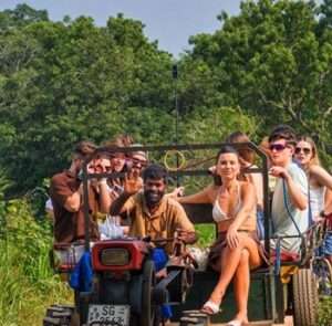 Visitors riding a tractor through a rural village landscape during a hiriwadunna Village Tour